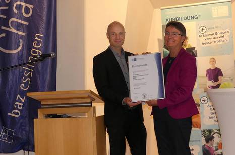 Christoph Nold, Leitender Geschäftsführer der IHK Region Stuttgart überreicht Anette Lang, Leiterin des BAZ Esslingen, eine Ehrenurkunde .